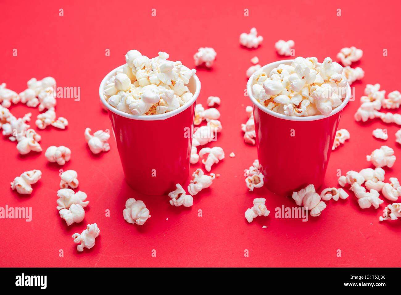Frische salzige Popcorn in zwei roten Karton Container, rote Farbe Hintergrund, Detailansicht Stockfoto