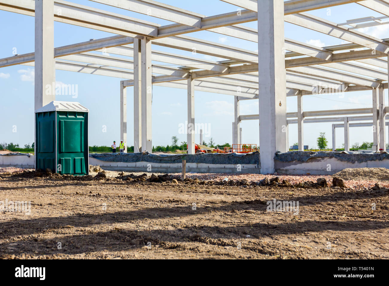 Beton Skelett des Unfertigen neue Gebäude und öffentlichen Toilette für Arbeitnehmer ist auf der Baustelle platziert. Stockfoto