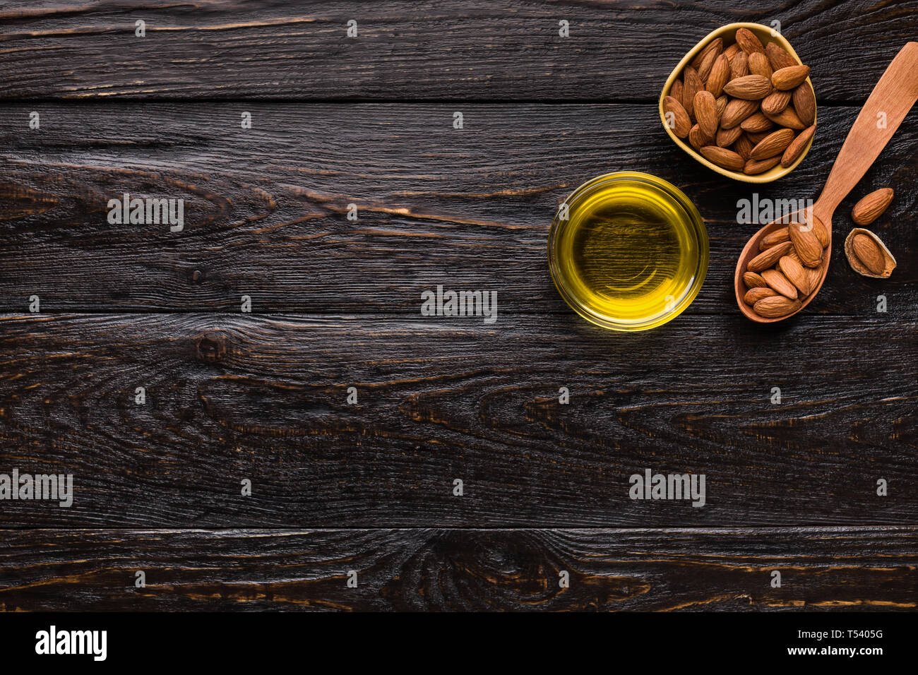 Schalen mit Mandelöl und Mandeln auf Holz- Hintergrund, Ansicht von oben, kopieren. Reine kaltgepresste Öle Konzept Stockfoto