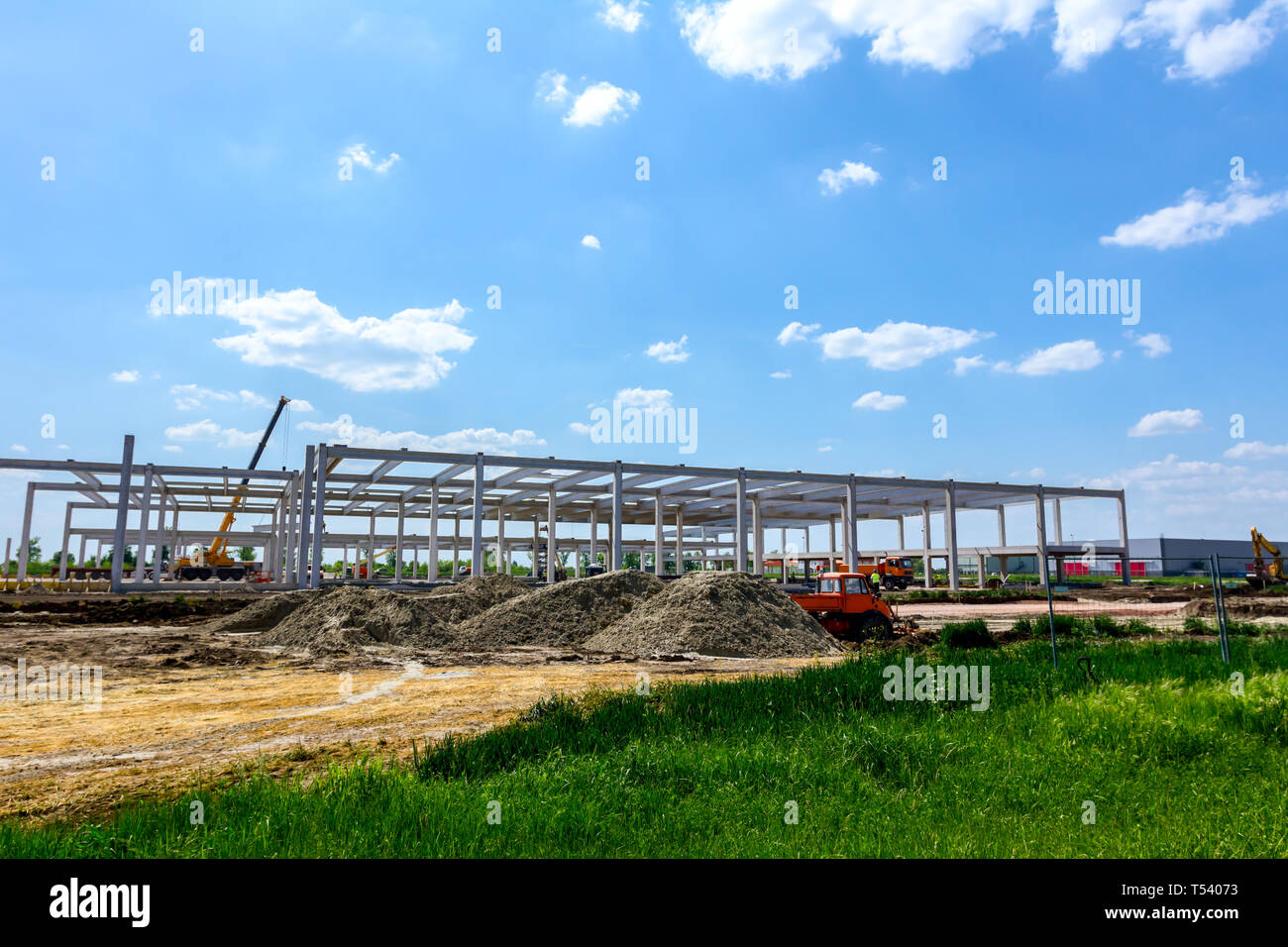 Montage einer riesigen Beton Skelett der industriellen Gebäude mit Maschinen, Menschen arbeiten. Blick auf die Baustelle. Stockfoto