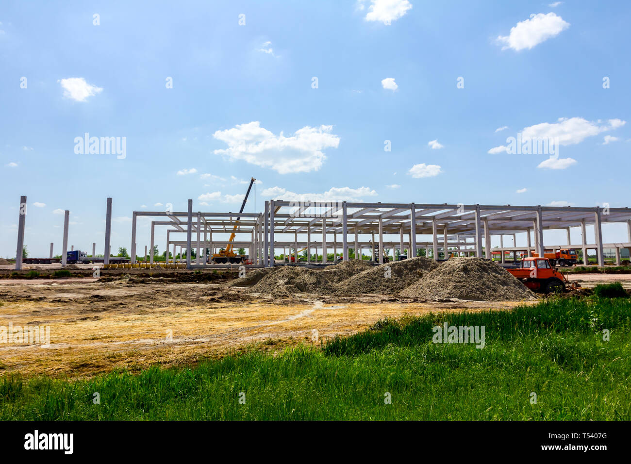 Montage einer riesigen Beton Skelett der industriellen Gebäude mit Maschinen, Menschen arbeiten. Blick auf die Baustelle. Stockfoto