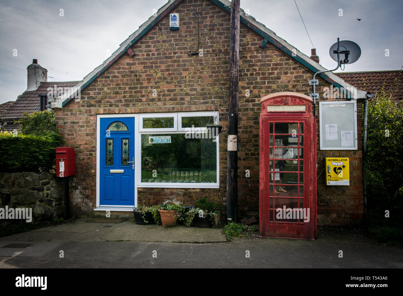 Alt und Neu. Sie sehen die alte Telefonzelle und Post Box gegen die neuen Defibrillator und modernen Shop in Yorkshire, UK. Stockfoto