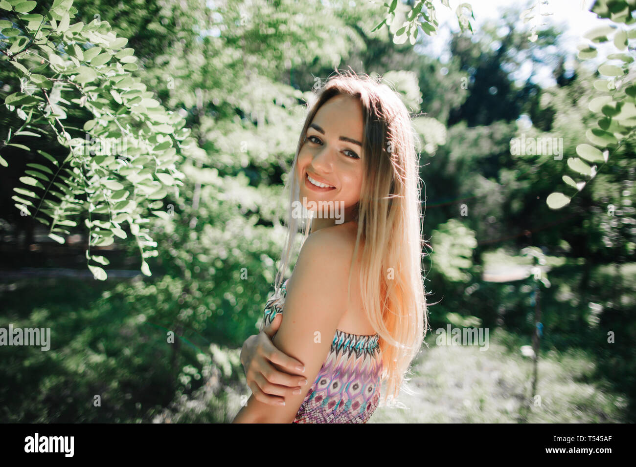 Junge Frau lächelnd in park Stockfoto