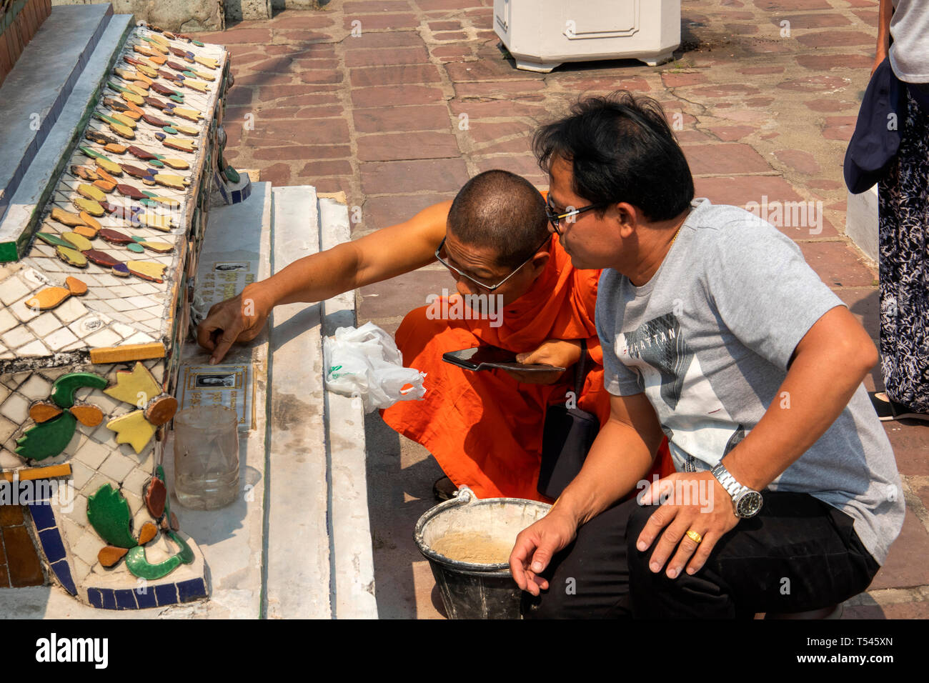 Th1064 Thailand, Bangkok, Wat Pho, Phra Maha Chedi, Mönch Beratung workman Anwendung Gedenktafel Chedi Stockfoto