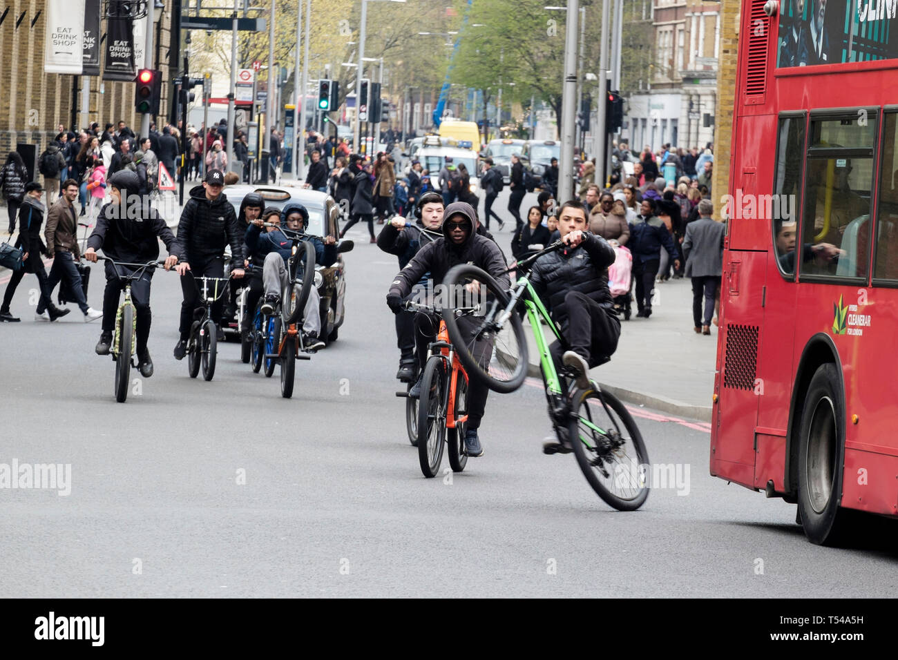 Teenager auf dem Fahrrad durchführen wheelie Stunts bei Besetzt die London Street. Großbritannien Stockfoto