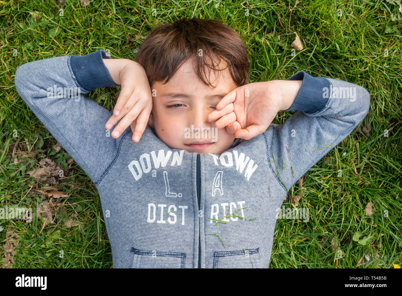 Junge liegt auf gras -Fotos und -Bildmaterial in hoher Auflösung – Alamy