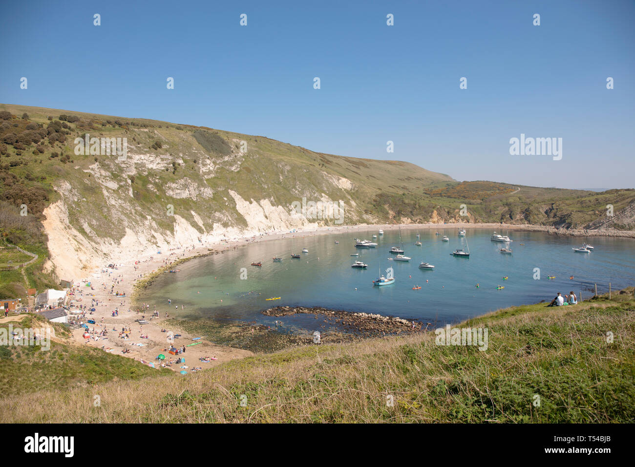 Die Menschen genießen die warme Ostern Feiertag wetter Lulworth Cove in Dorset 2019 Stockfoto
