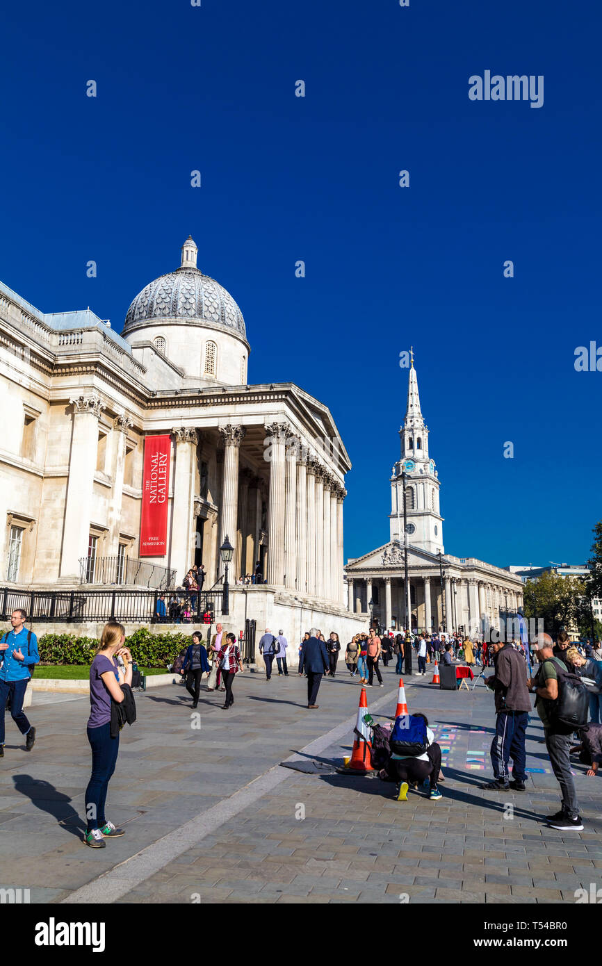 Von außen die National Gallery am Trafalgar Square und St Martin-in-the-Fields Kirche im Hintergrund, Menschen Zeichnen mit Kreide, London, UK Stockfoto