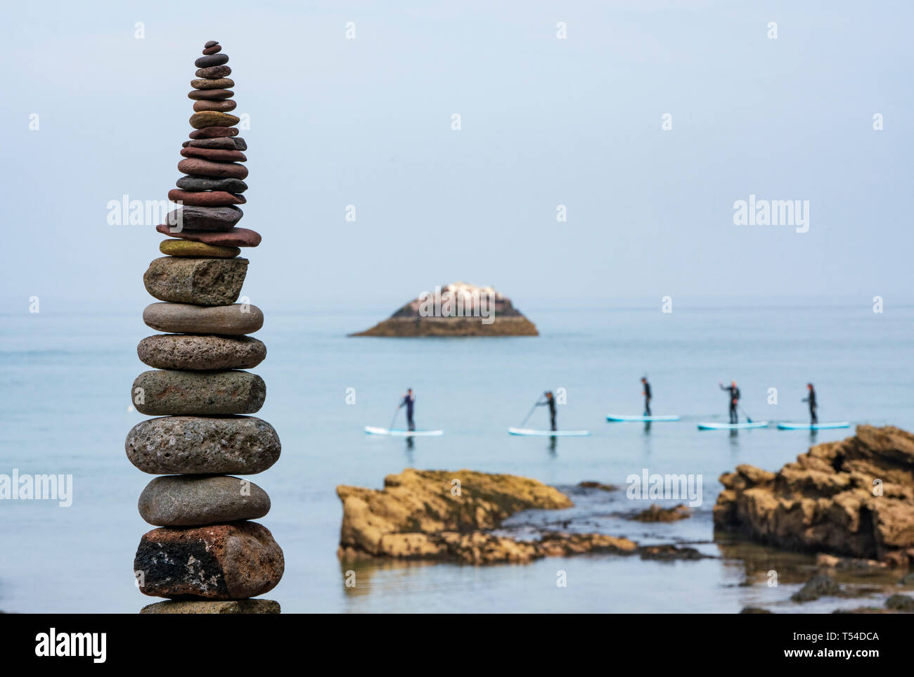 Dunbar, Schottland, Großbritannien. 20 Apr, 2019. Paddel Boarder und Stein am Auge Cave Beach Stack in Dunbar bei der Eröffnung der Europäischen Stein Stacking Meisterschaft 2019. Credit: Iain Masterton/Alamy leben Nachrichten Stockfoto