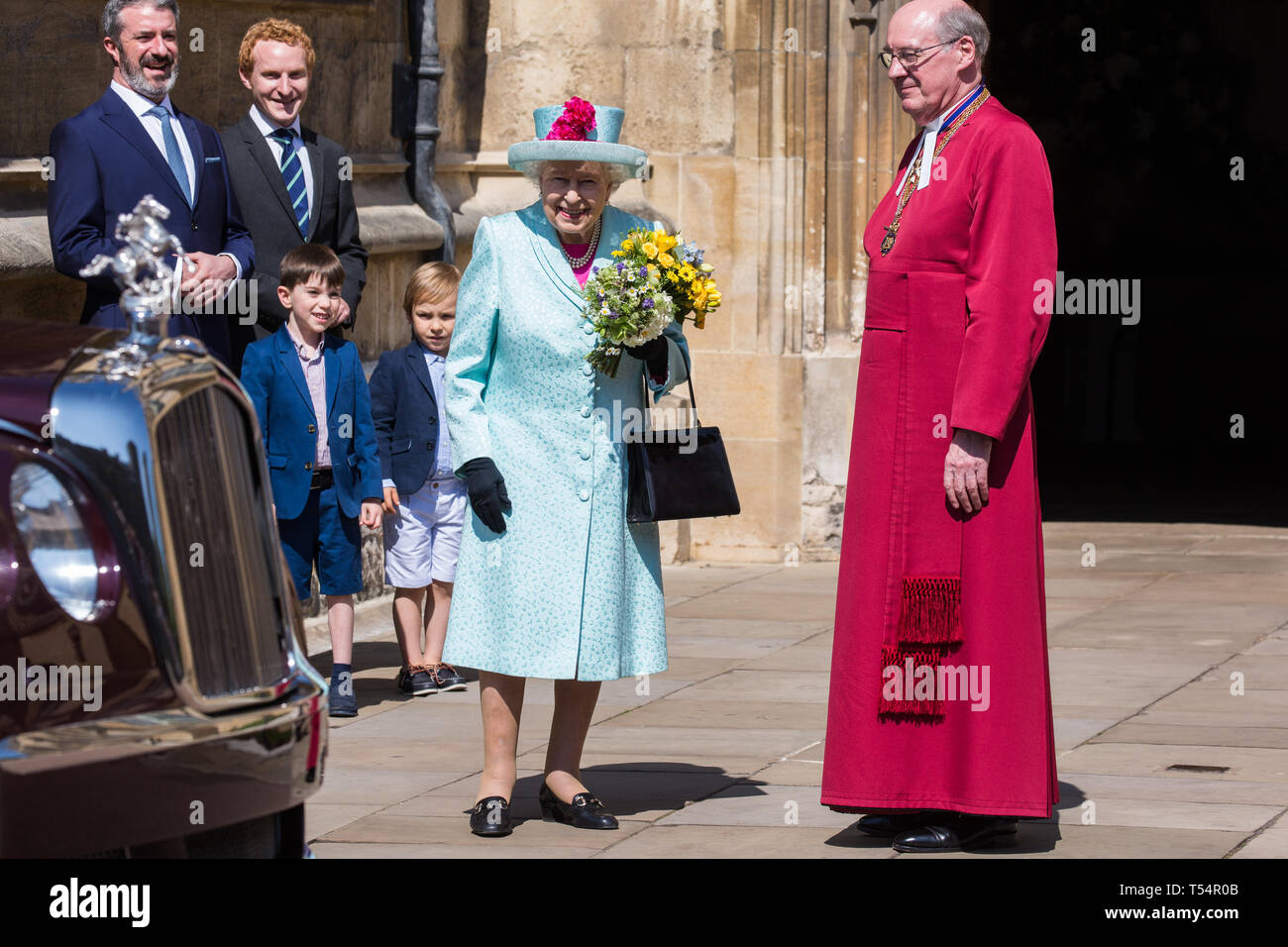 Windsor, Großbritannien. 21. April 2019. Die Königin bereitet vor sich, nachdem sie mit einem traditionellen posy von Blumen von zwei Jungen außerhalb der St. George's Chapel in Windsor Castle nach dem Ostersonntag Service vorgestellt. Credit: Mark Kerrison/Alamy leben Nachrichten Stockfoto