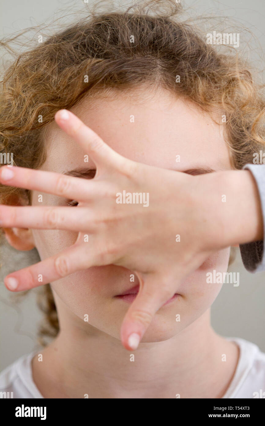 Portrait eines Mädchens mit einer Hand vor ihrem Gesicht Stockfoto