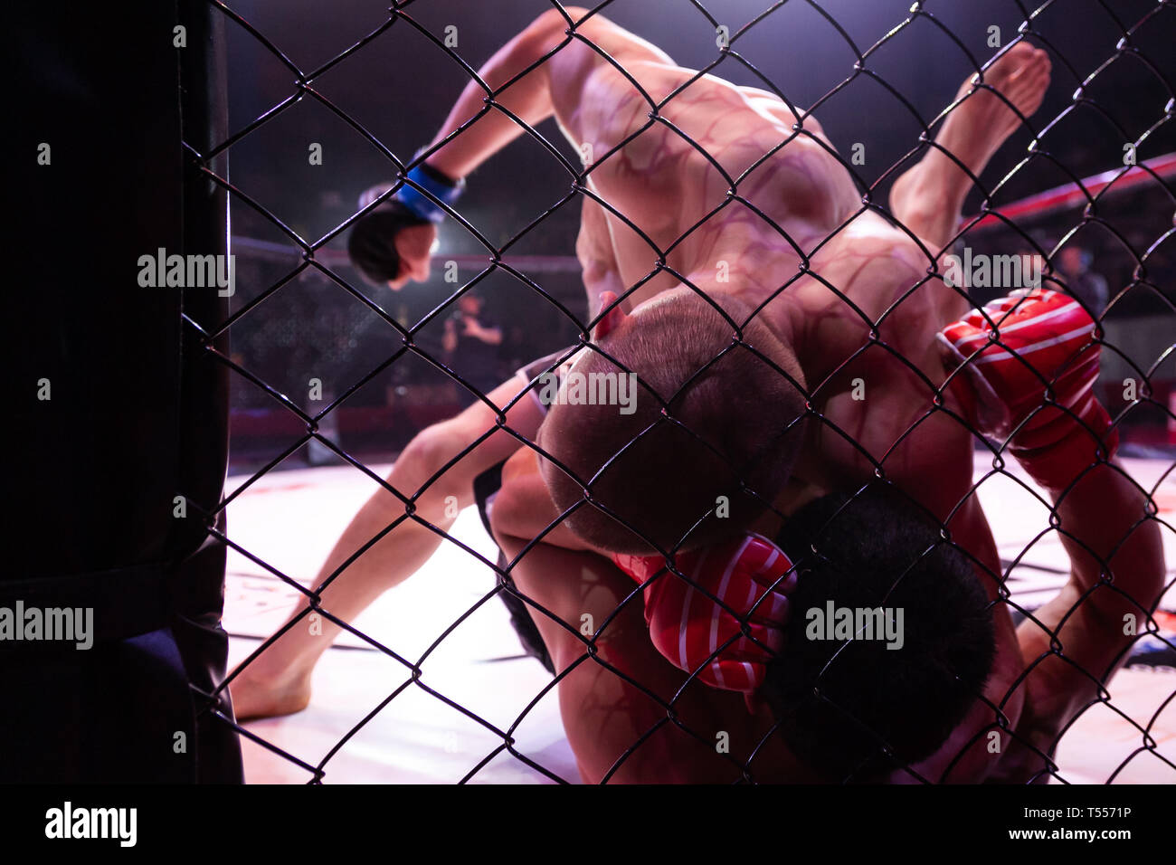 Die Nahaufnahme ist ein professioneller starke MMA-Kämpfer Holding ein Rivale und markante Ihn in einem Kampf in der Arena der achteckige Szene. Die Stimmung und die Konz Stockfoto