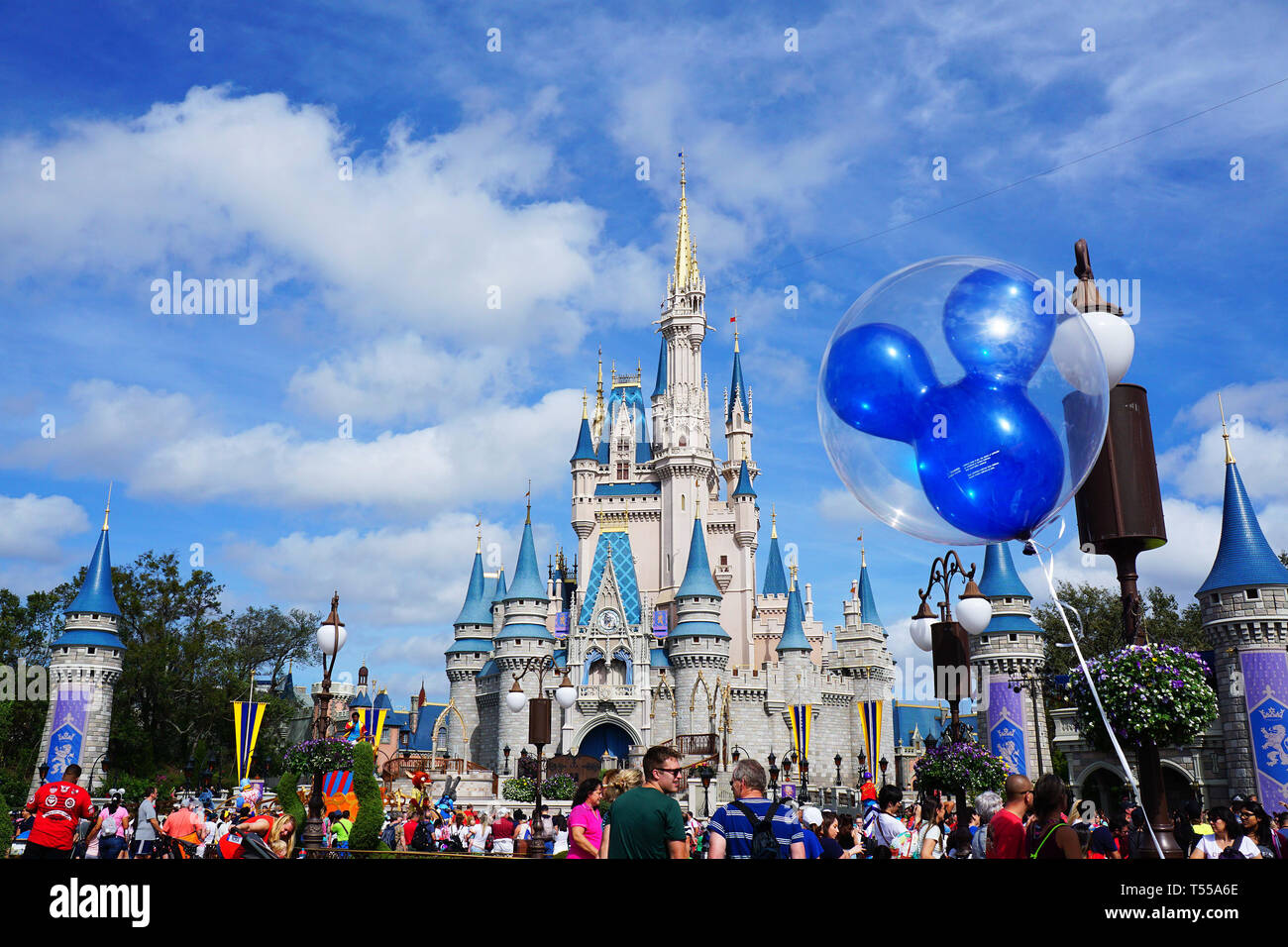 Orlando, Florida/USA - 02/07/18 - Cinderella Schloss mit einem Mickey Mouse Ballon vor und Menschen zu Fuß rund um einen schönen Tag genießen. Stockfoto