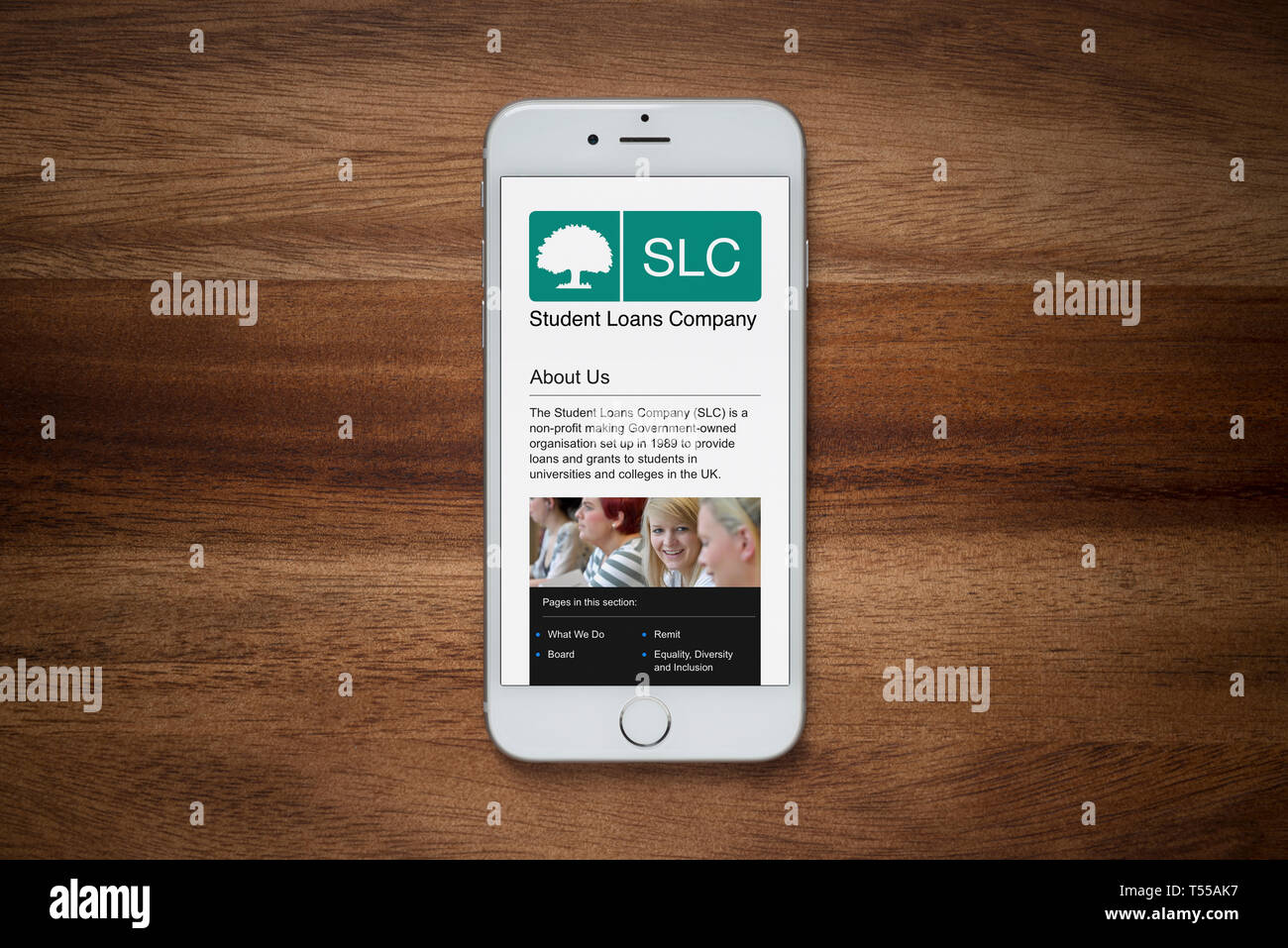 Ein iPhone mit der Student Loans Company Website beruht auf einem einfachen Holztisch (nur redaktionelle Nutzung). Stockfoto