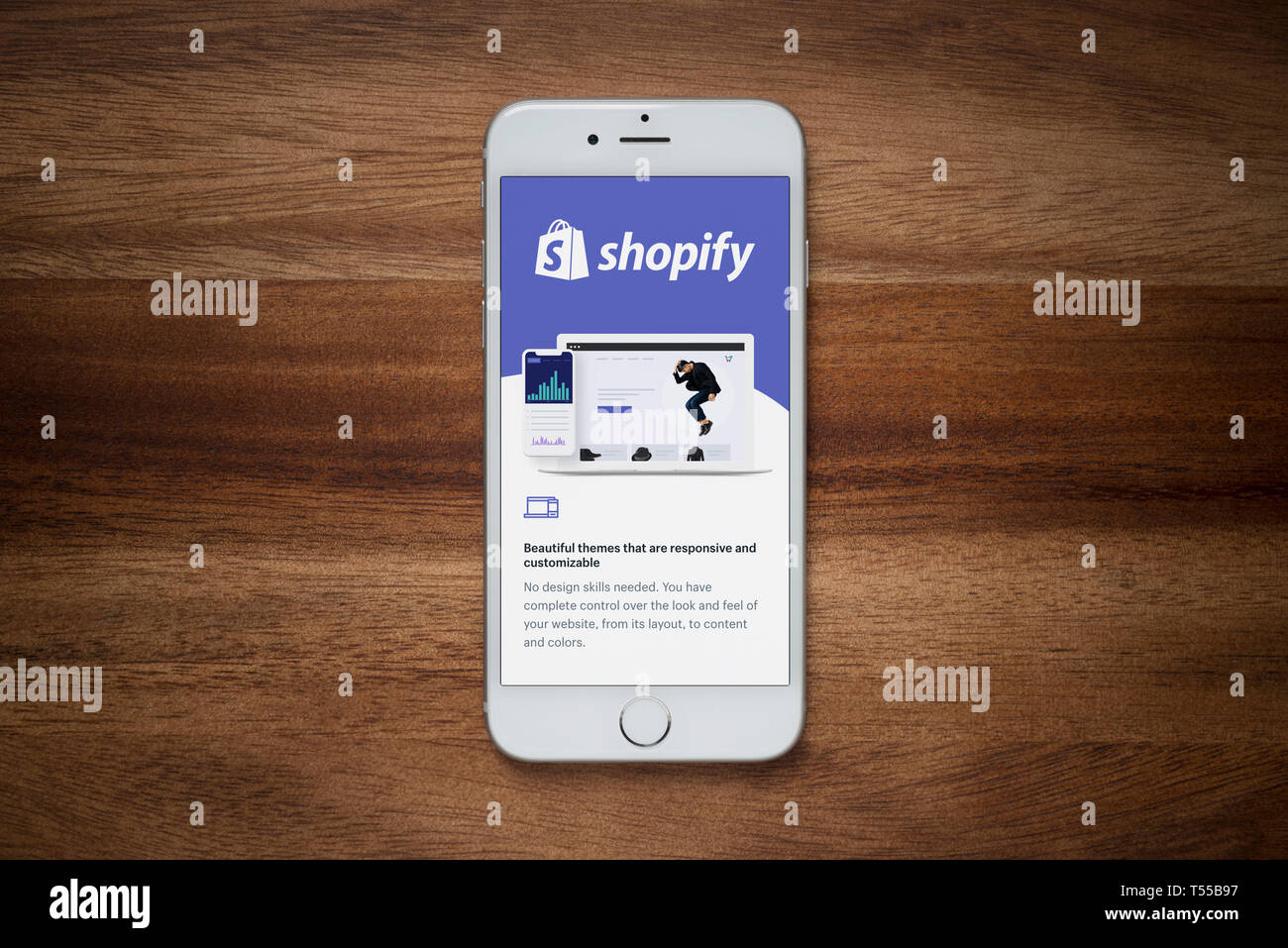 Ein iPhone zeigt die Shopify Website beruht auf einem einfachen Holztisch (nur redaktionelle Nutzung). Stockfoto