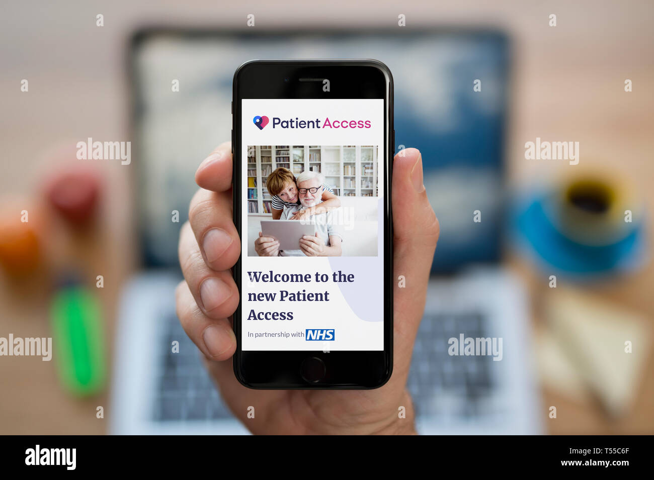 Ein Mann schaut auf seinem iPhone wird der Patient Access Logo (nur redaktionelle Nutzung). Stockfoto