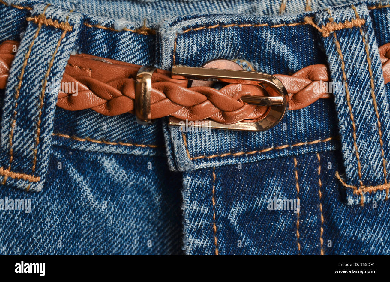 Leder braun geflochtene gürtel versteckt in Jeans close-up. Stockfoto