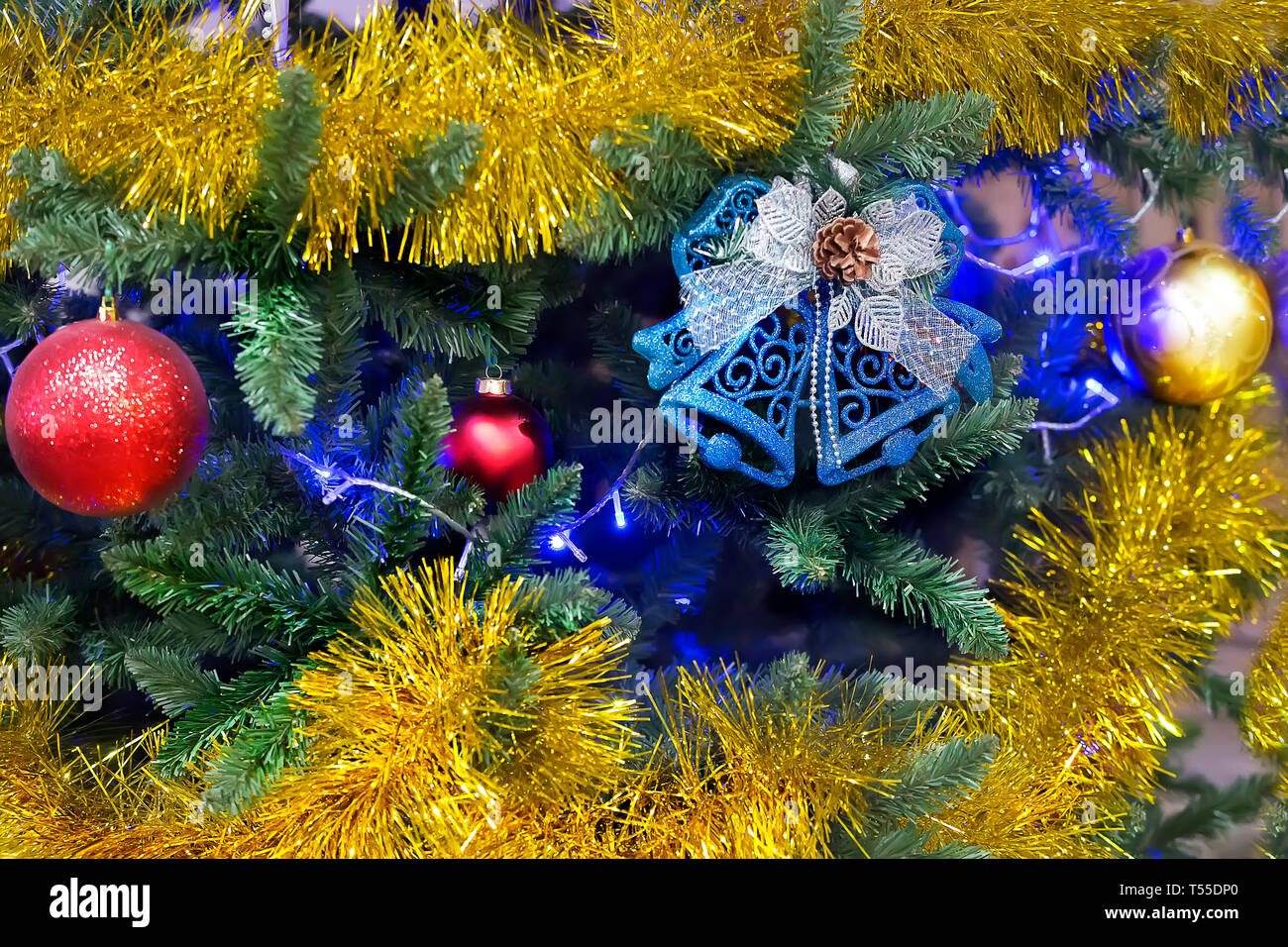 Hintergrund des neuen Jahres. Weihnachtsbaum mit lametta Spielzeug und Glocken Stockfoto