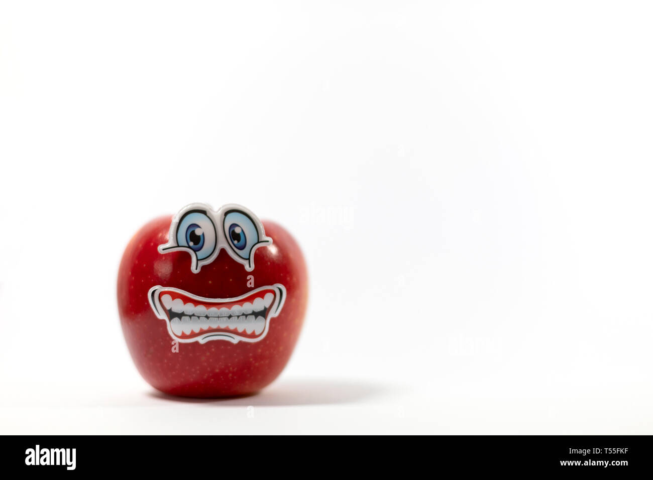 Saftige rote Apfel mit einem besorgt Cartoon wie Gesicht, Kindern eine gesunde Lebensweise, auf einem weißen Hintergrund zu führen Stockfoto