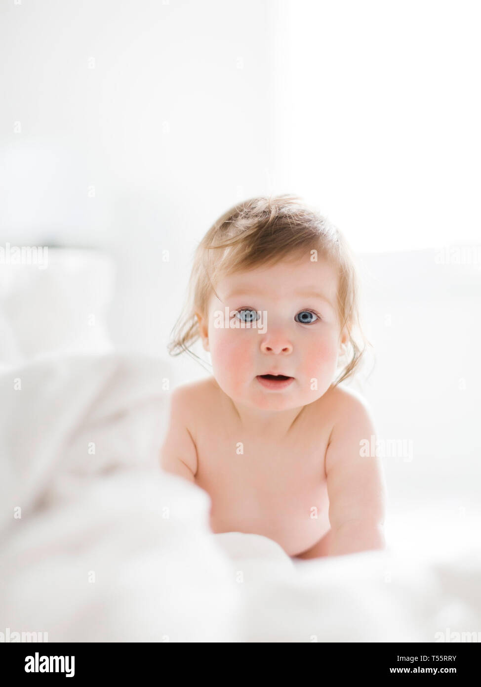 Baby Mädchen liegt auf einem weißen Blatt Stockfoto