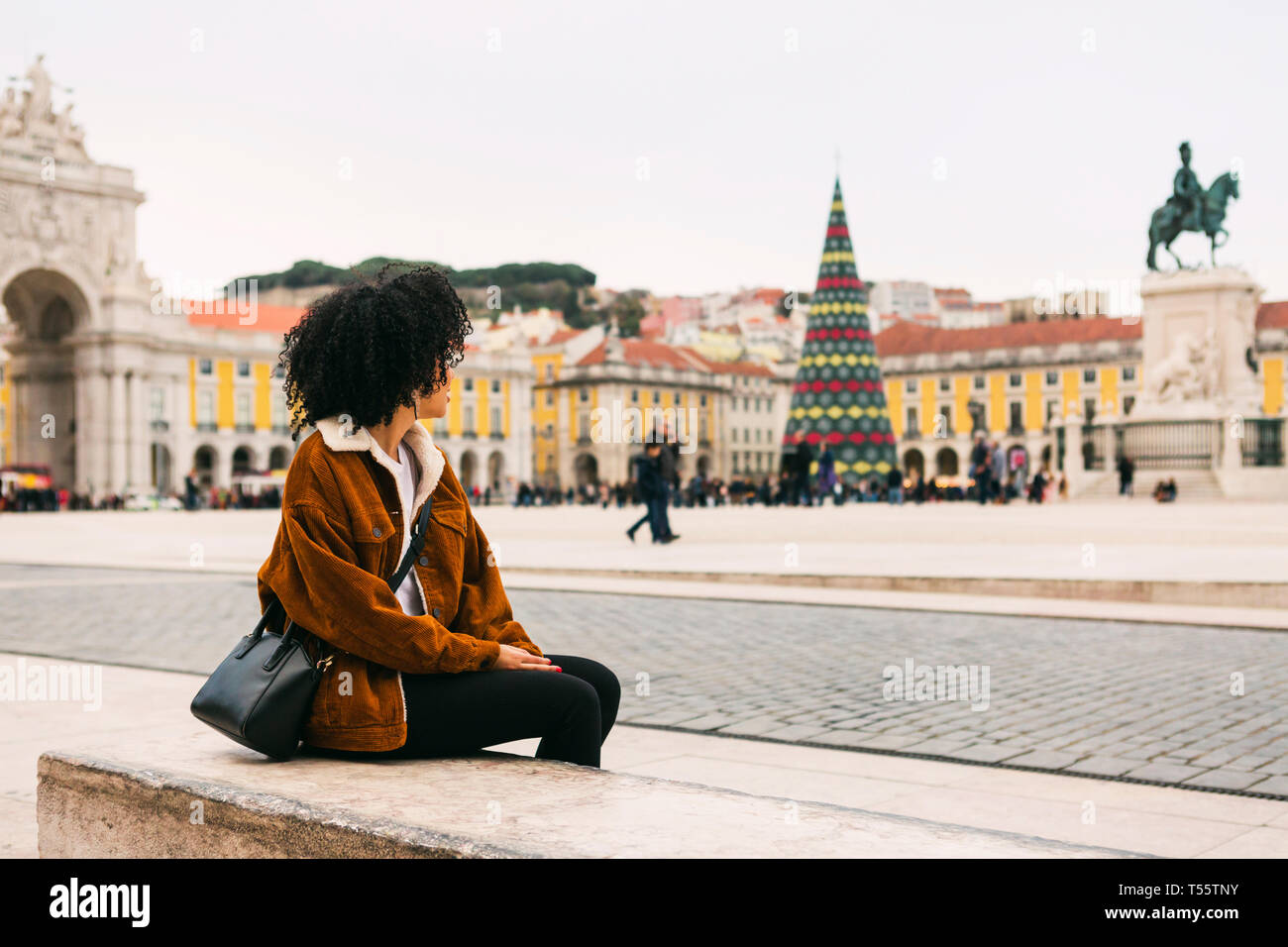 Junge Frau in Town Square in Lissabon, Portugal, sitzen Stockfoto