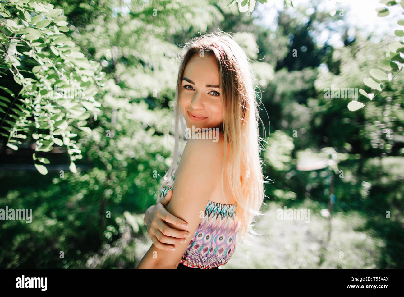 Junge Frau lächelnd in park Stockfoto