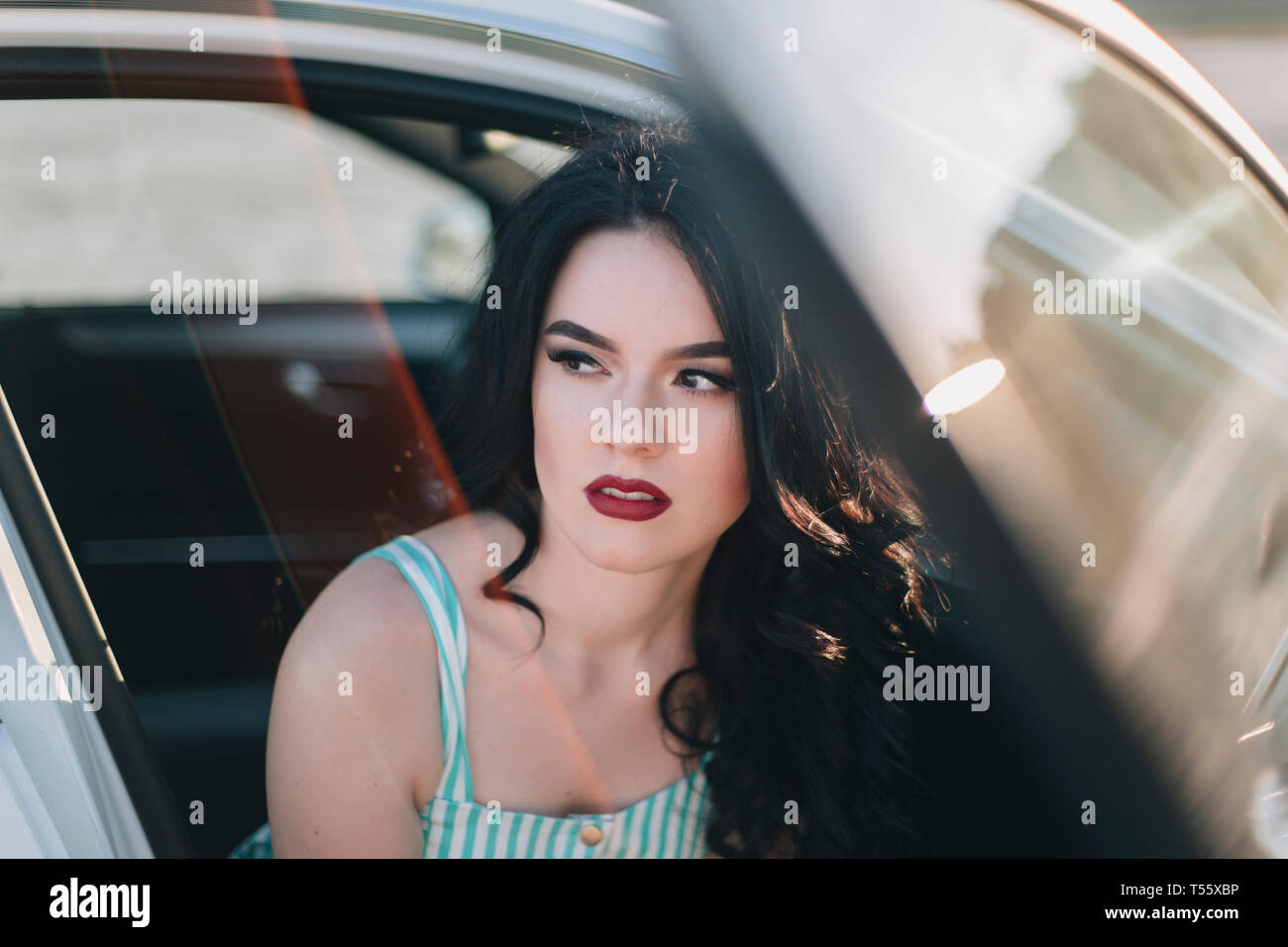 Junge Frau das Tragen der roten Lippenstift im Auto sitzen Stockfoto
