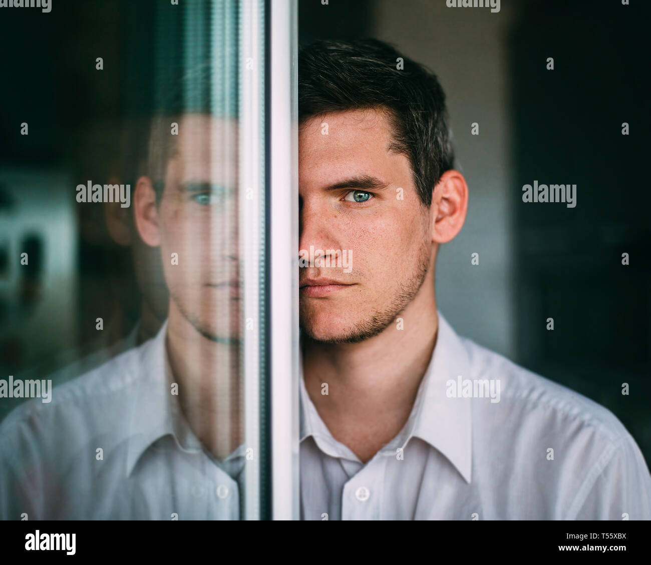 Porträt des Menschen auf der Suche um Glastür Stockfoto