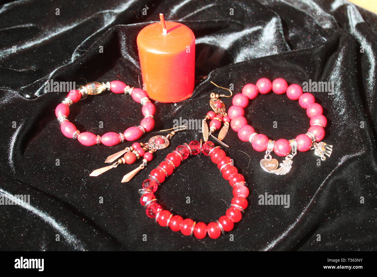 Helles Rot Armband mit Ohrring und rote Kerze für zen Heilung und Meditation Stockfoto
