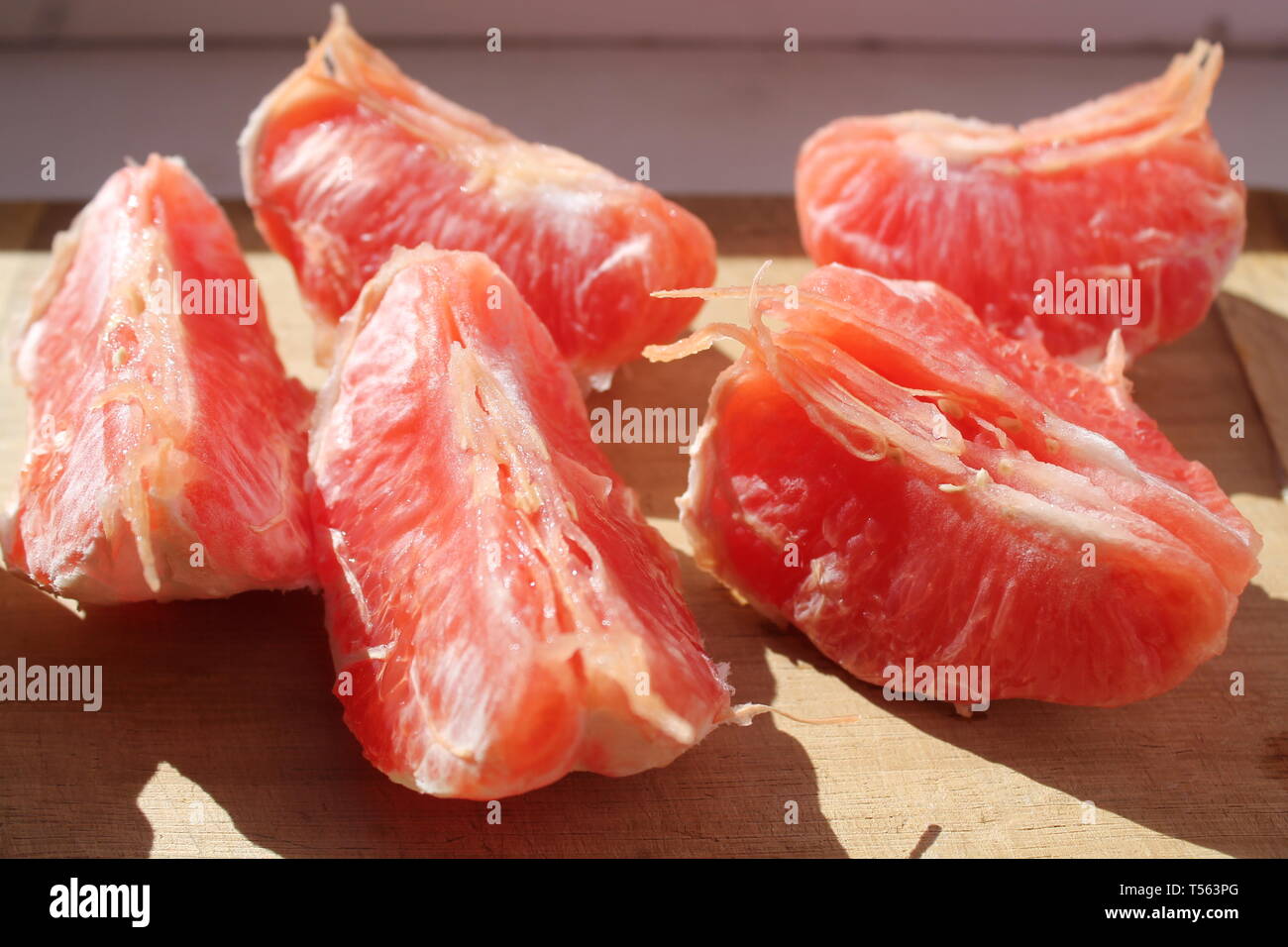 Saftige süsse rosa Grapefruit Schichten auf Tisch legen Stockfoto