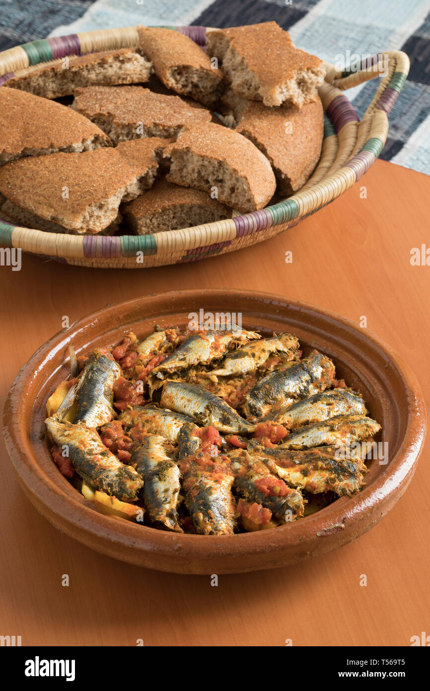 Traditionelle marokkanische Tajine mit Sardinen, Gemüse und Brot für das Abendessen Stockfoto
