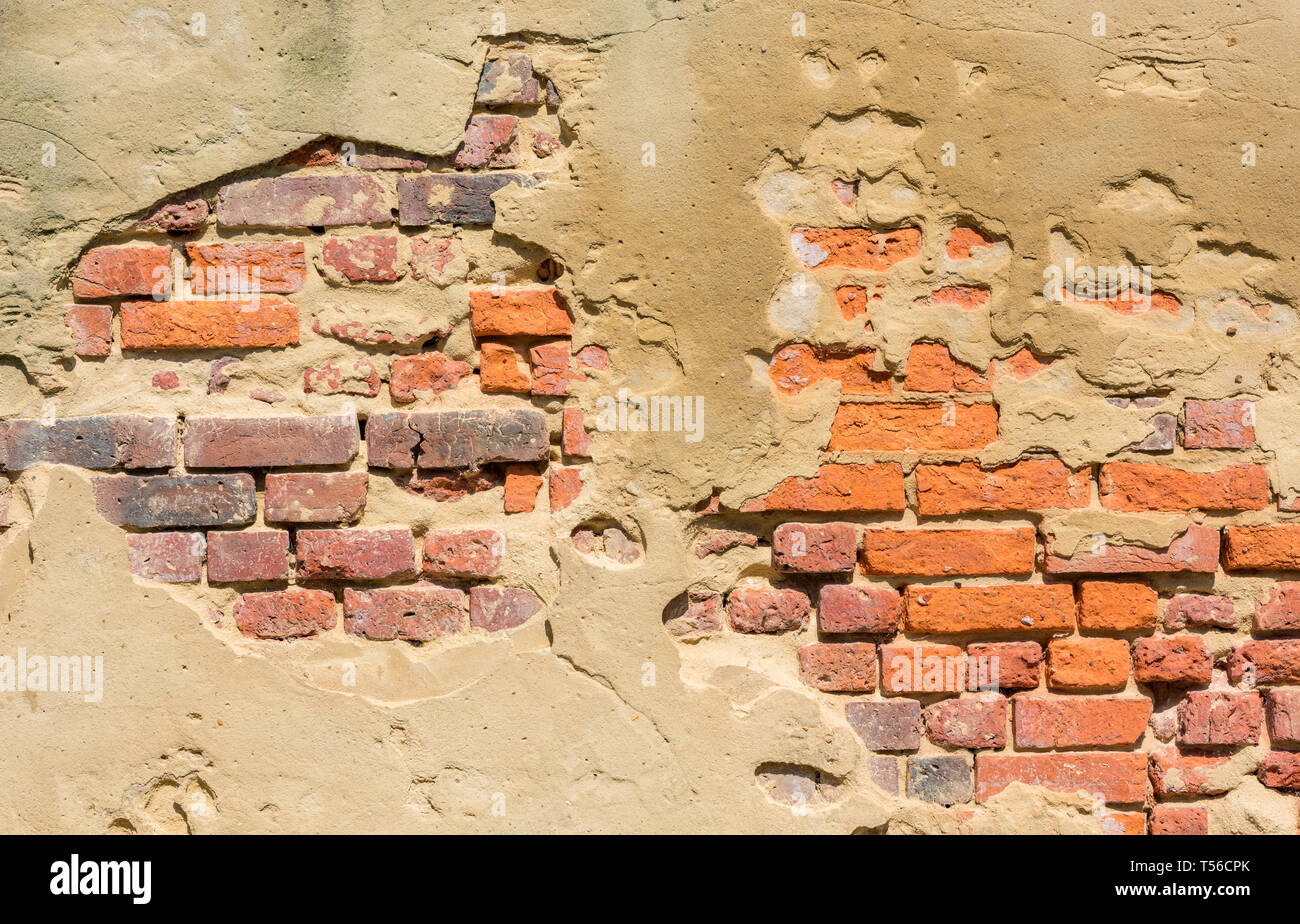 Gips oder Rendern auf eine Wand abblätternde Putz und roten Ziegeln in der Notwendigkeit von Reparaturen Mörtel. Stockfoto