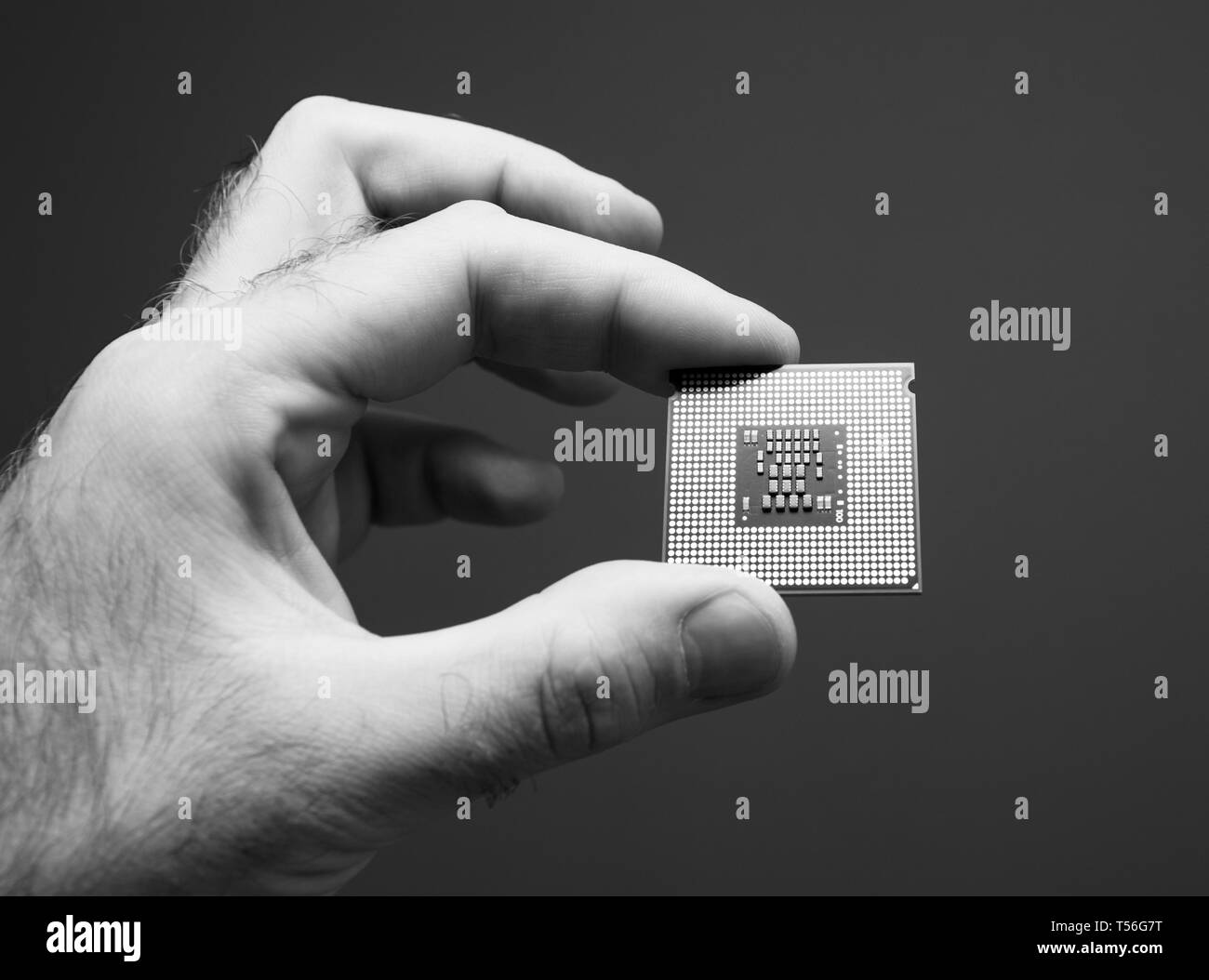 Männliche IT professional Holding in der Hand neue leistungsstarke CPU Central Processing Unit mit Hohe Kernanzahl und erhöhte Frequenz - Schwarz/Weiß-Bild Stockfoto