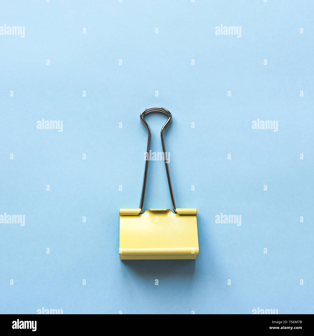 Gelbe Klammer auf blauem Hintergrund. Ansicht von oben. Stockfoto