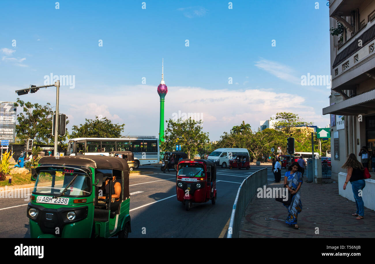Colombo, Sri Lanka - April 5, 2019: Downtown Colombo Street Szene mit Lotus Tower im Hintergrund und Tuk-tuk auf der Straße mit Passanten Stockfoto
