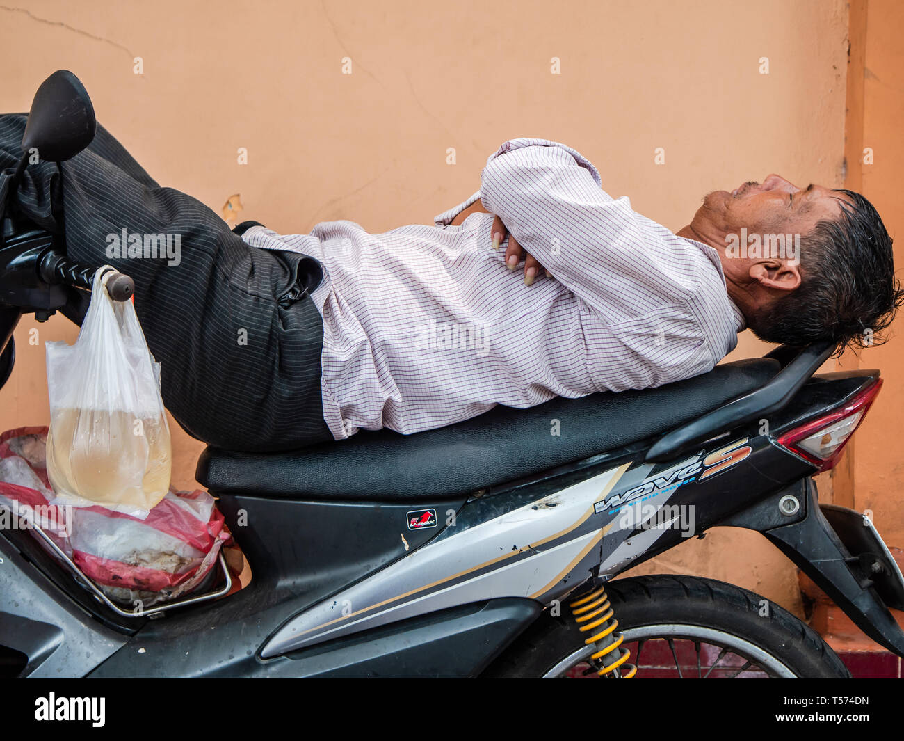 Vietnamesische Motorrad fahrer eine Pause mit seinem Motorrad in einer Straße von Ho Chi Minh City, Vietnam. Stockfoto