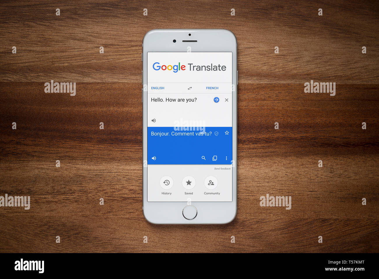 Ein iPhone mit Google Translate Website beruht auf einem einfachen Holztisch (nur redaktionelle Nutzung). Stockfoto