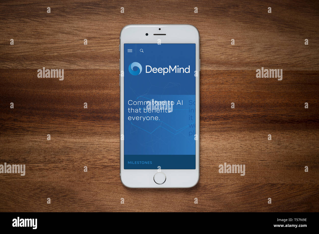 Ein iPhone mit der DeepMind Website beruht auf einem einfachen Holztisch (nur redaktionelle Nutzung). Stockfoto