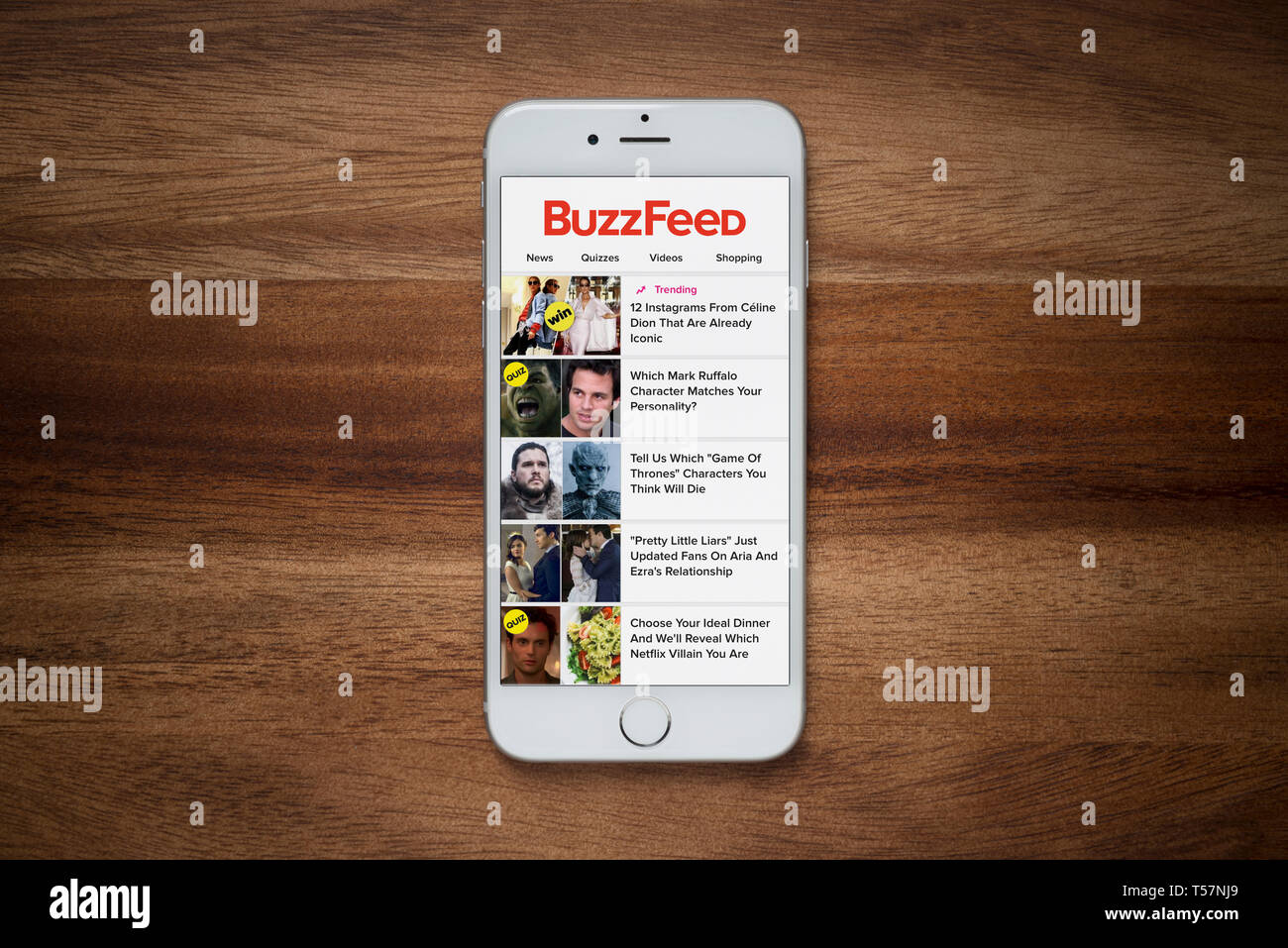 Ein iPhone zeigt die Buzzfeed Website beruht auf einem einfachen Holztisch (nur redaktionelle Nutzung). Stockfoto