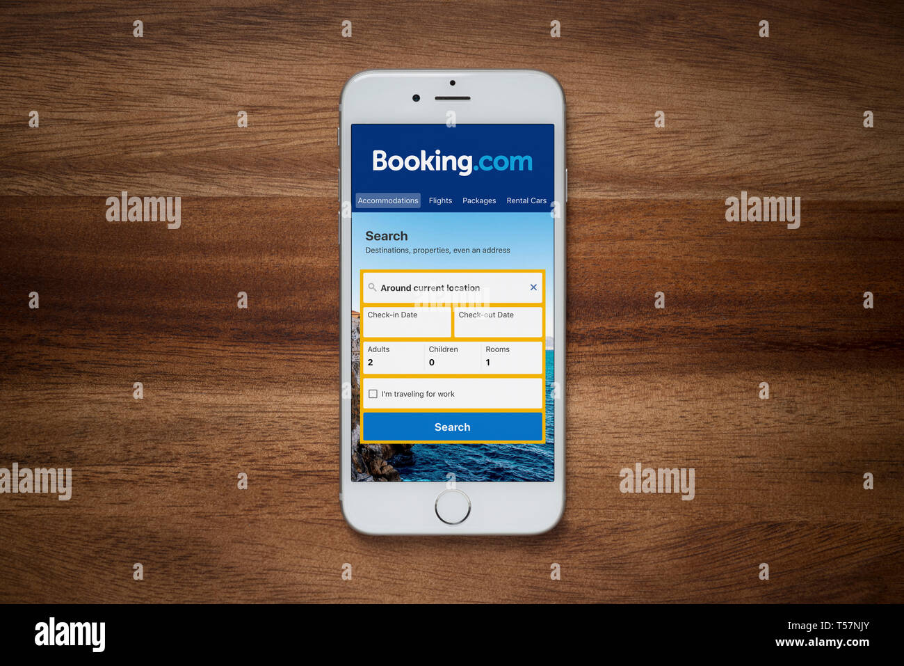 Ein iPhone zeigt die Booking.com Webseite beruht auf einem einfachen Holztisch (nur redaktionelle Nutzung). Stockfoto