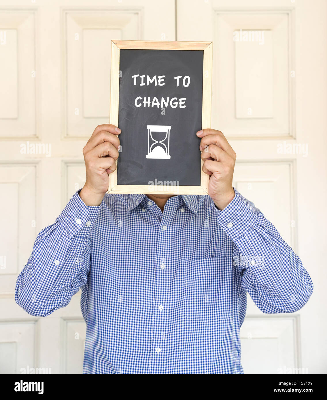 Die Zeit zu ändern, Wörter und eine Zeit auf einem schwarzen Brett vor das Gesicht ein Mann Stockfoto