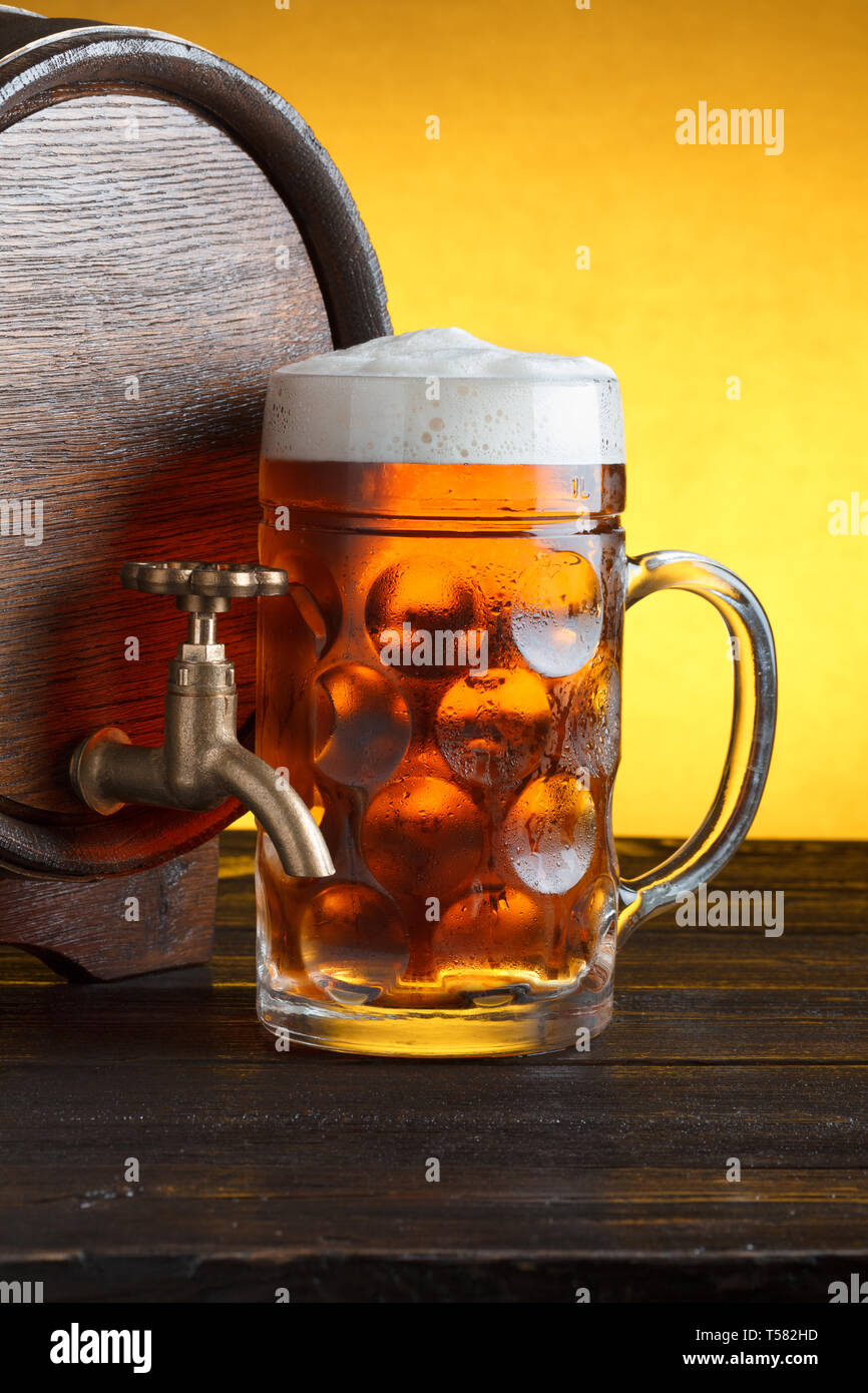 Vintage Barrel Bier mit riesigen Bier Glas auf hölzernen Tisch noch leben Nahaufnahme Stockfoto