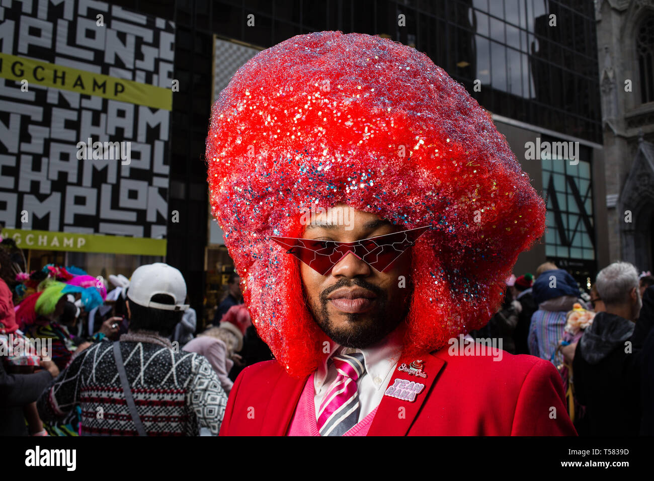 New York, NY - 21. April 2019. Einen Afrikaner Mann in einem überdimensionalen roten Afro am Ostern Mütze Parade und Festival auf der New Yorker Fifth Ave Stockfoto