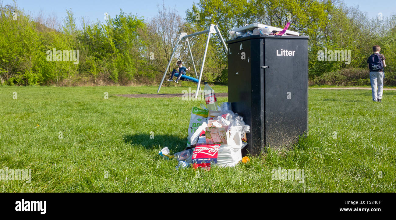 Überquellenden Mülleimer in einem Land Park mit Kinderspielplatz Stockfoto