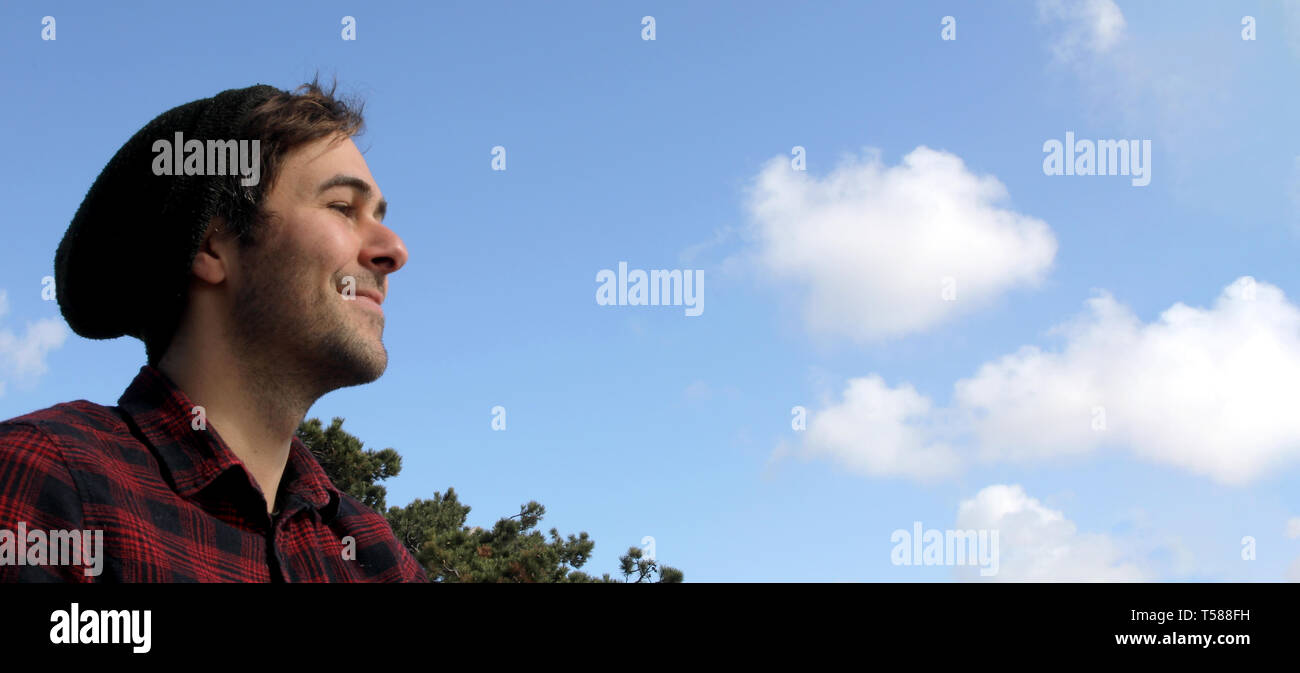 Authentische kaukasischen Hipster lächeln Banner mit blauem Himmel und Wolken. Stockfoto