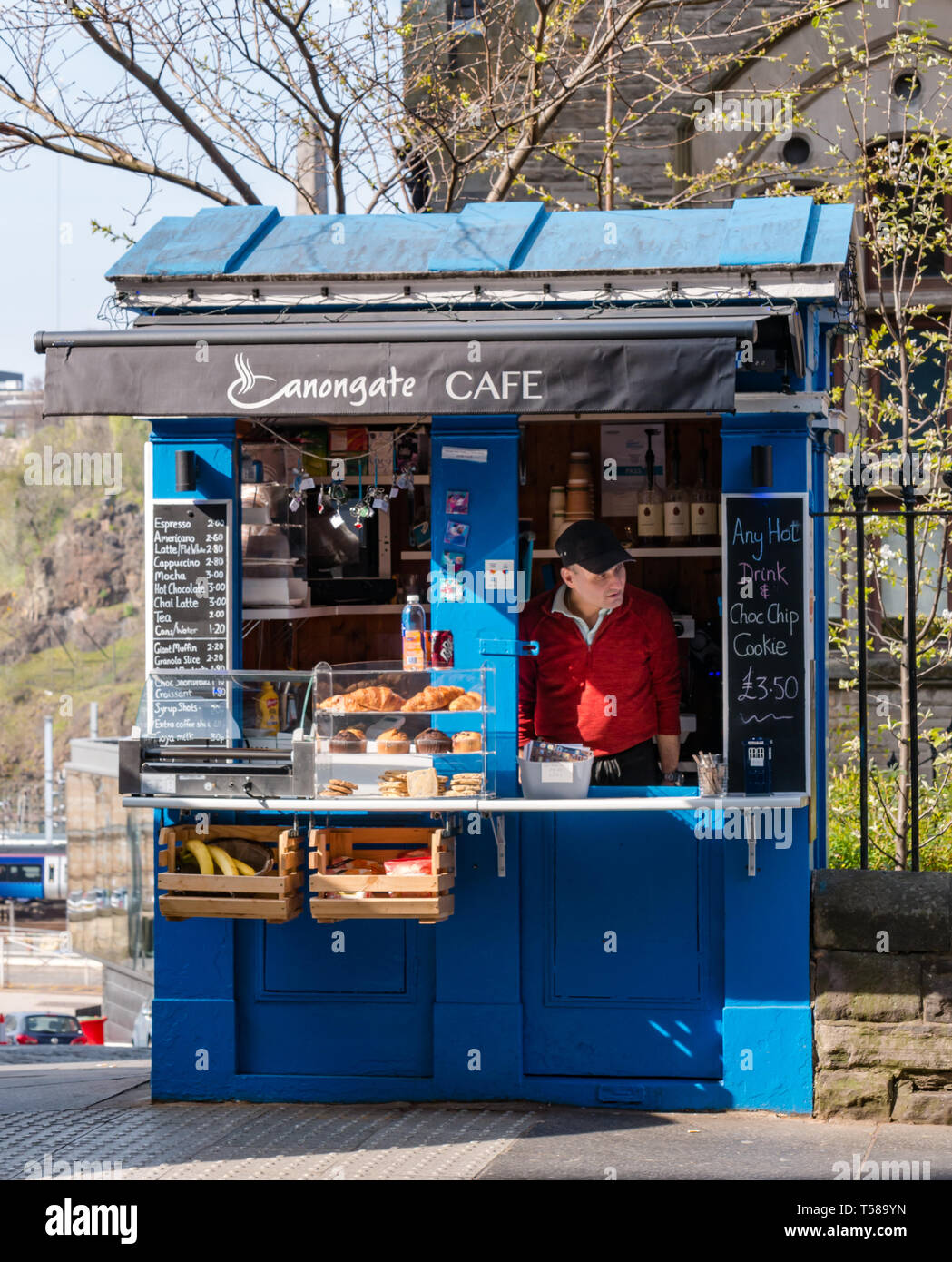 Alte Polizei rufen, umgewandelt zu Kaffee zum Mitnehmen ausgeht, Carl's Cafe, Royal Mile, Edinburgh, Schottland, Großbritannien mit Inhaber auf der Suche nach Kunden Stockfoto