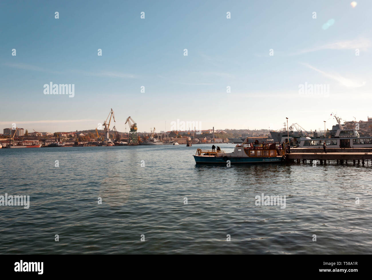 Vladivostok, Russland - NOVEMBER 4,2018: Blick auf den Hafen mit Kränen und Fischer in einem Boot Stockfoto