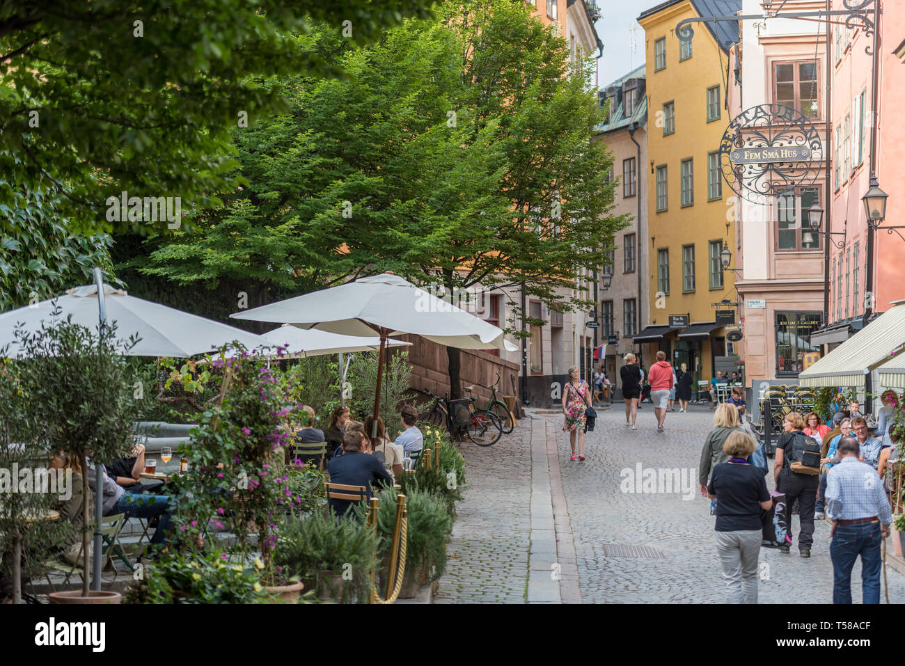Touristen und Einheimische genießen Sie die bunten historischen Umgebung von Stockholm Gamla Stan (Altstadt). Stockfoto