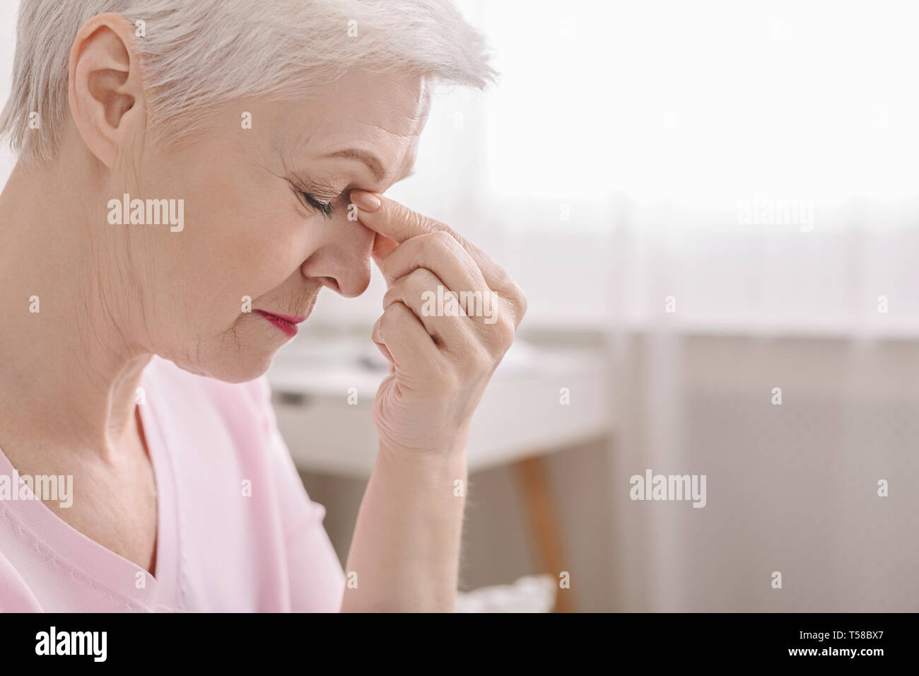 Ermüdet senior Frau massieren Nasensteg, Gefühl der Belastung der Augen Stockfoto