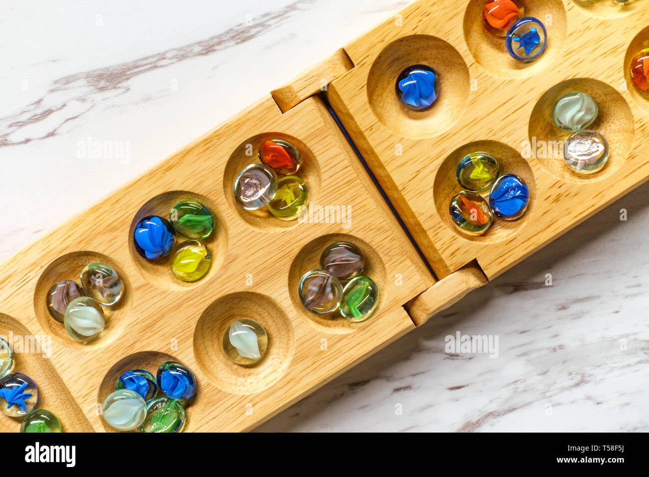 Traditionelle Mancala Brettspiel mit Glas Stücke auf Marmor tisch Stockfoto
